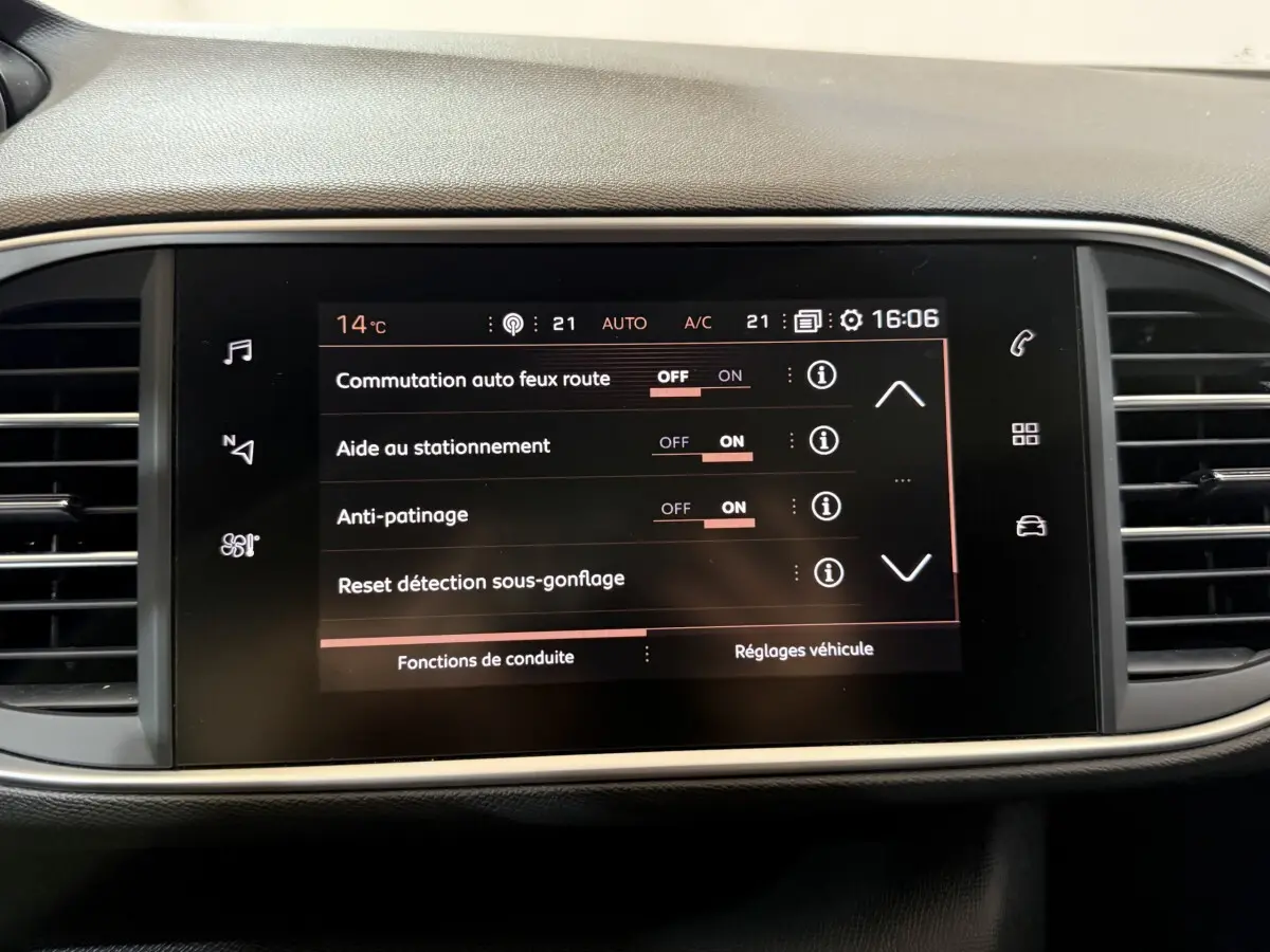 Écran tactile central affichant les réglages d'aide à la conduite dans l'habitacle d'une Peugeot 308 noire de 2020.