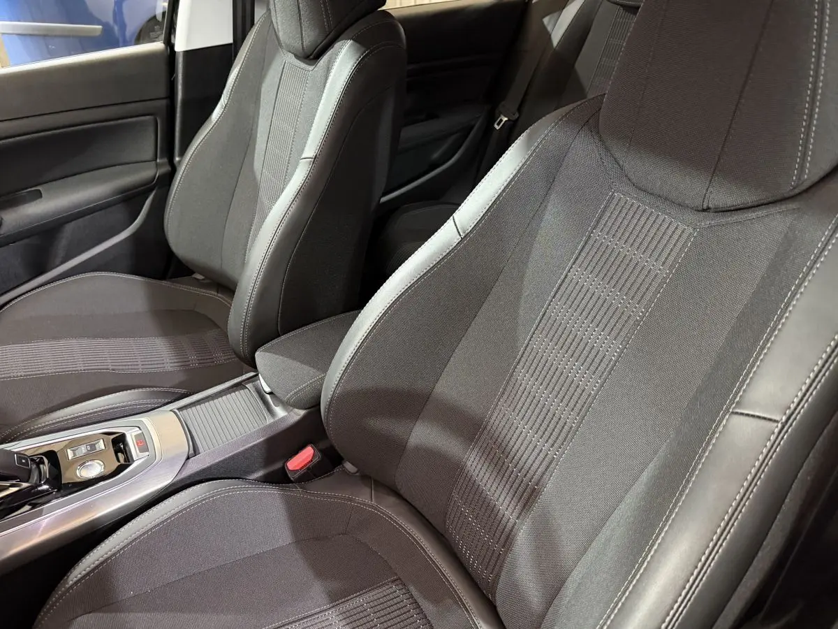 Gros plan sur les sièges avant noirs en tissu et cuir de la Peugeot 308 Puretech 130 Allure 2020, côté conducteur et passager.