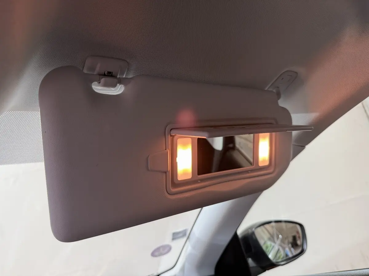 Miroir de courtoisie éclairé sur pare-soleil côté gauche dans l'habitacle d'une Peugeot 308 noire de 2020.