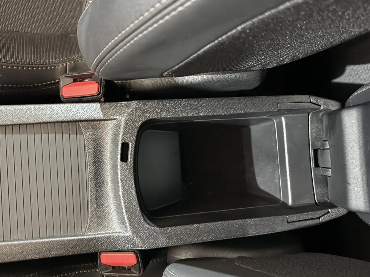 Vue plongeante sur le rangement central noir entre les sièges avant d'une Peugeot 308 Allure 2020.