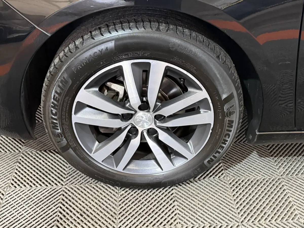 Gros plan sur la roue avant droite noire d'une Peugeot 308 2020 avec jante alliage et pneu Michelin.