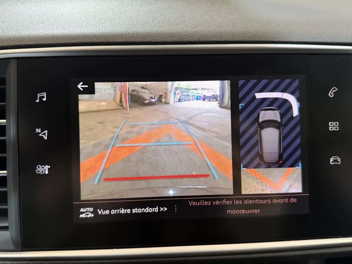 Affichage écran tactile montrant la caméra de recul et l'aide au stationnement du tableau de bord Peugeot 308 noir.