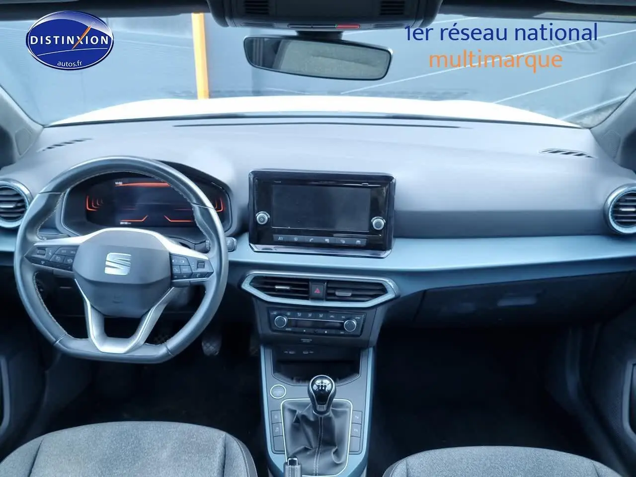 Vue intérieure frontale du tableau de bord et volant cuir multifonction de la SEAT Arona blanche 2023, boîte manuelle.