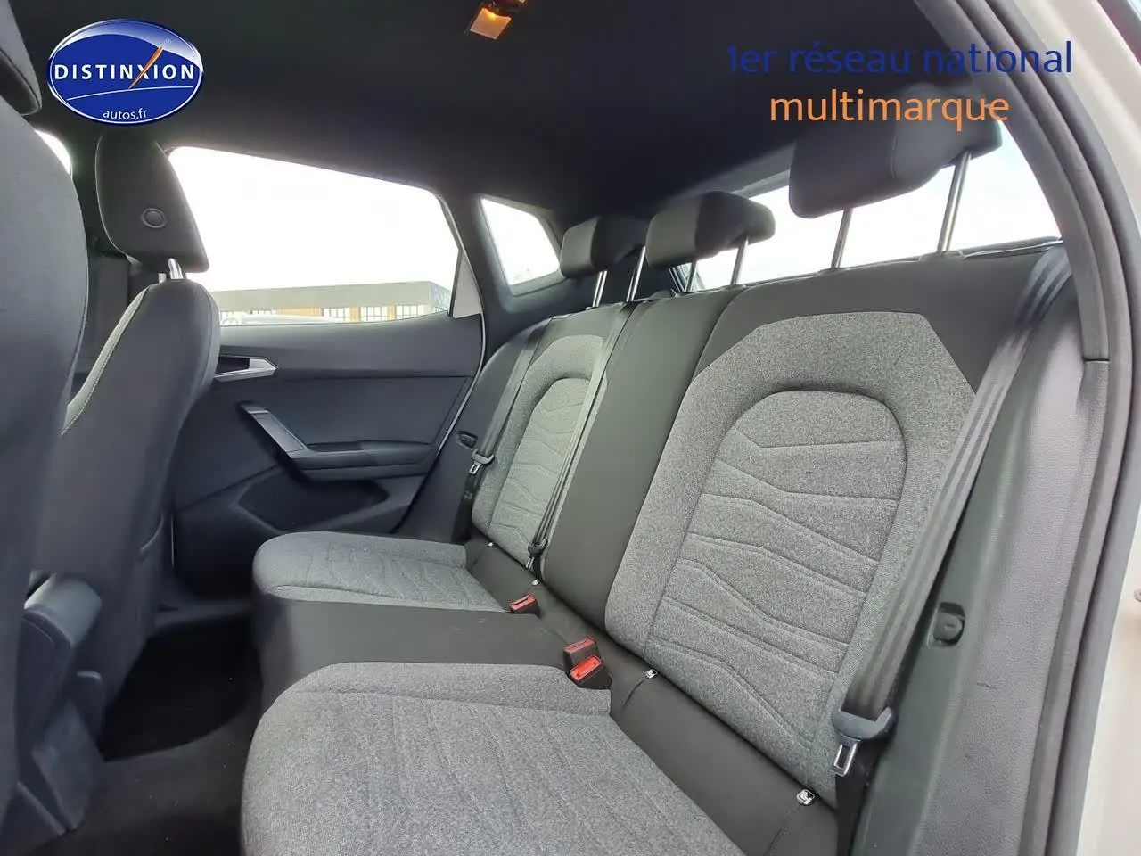 Vue intérieure côté droit montrant la banquette arrière grise et noire du SEAT Arona blanc 2023.