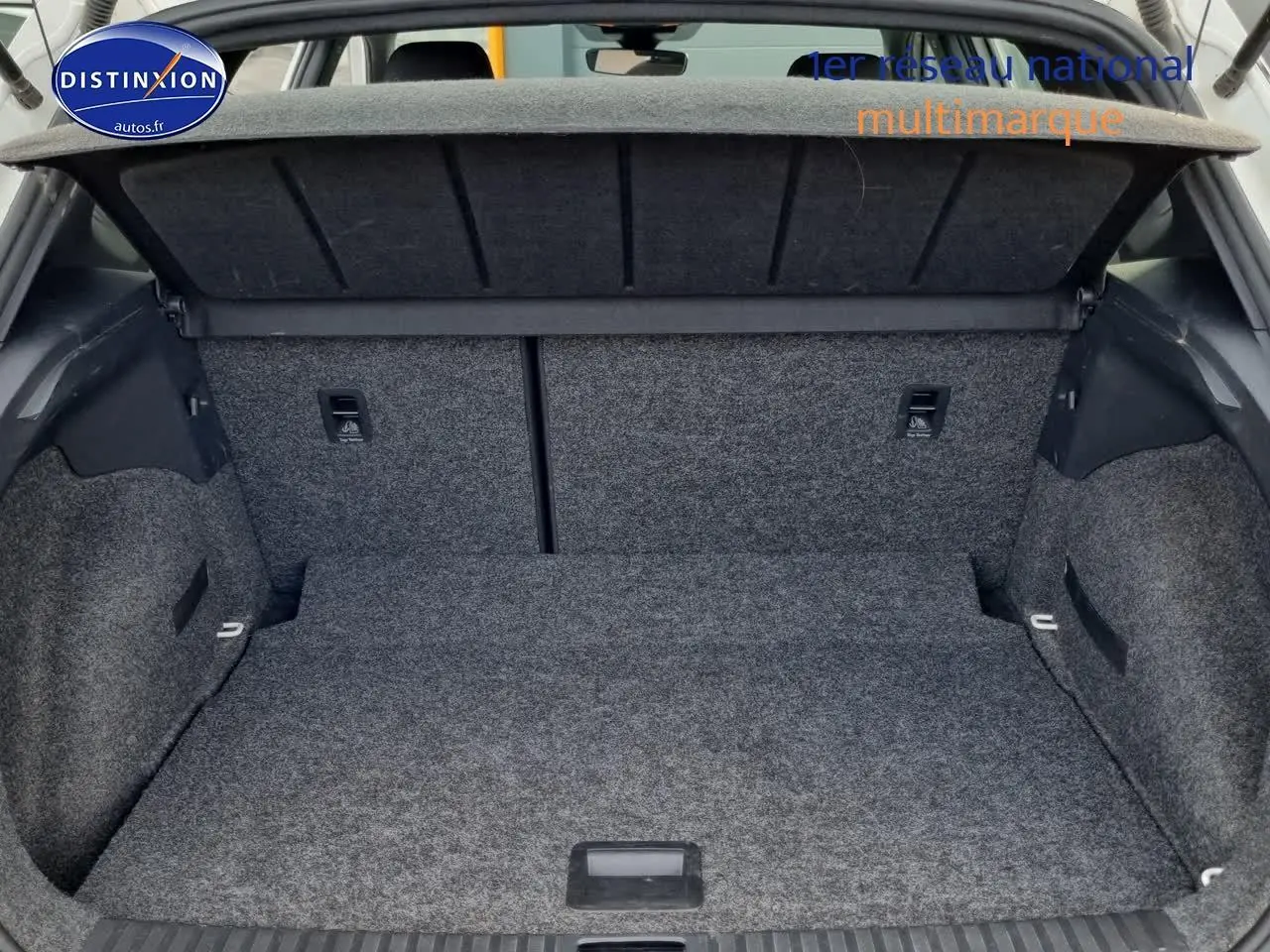 Coffre ouvert vu de l'arrière d'un SEAT Arona blanc 2023, montrant l'espace de chargement et la tablette cache-bagages.