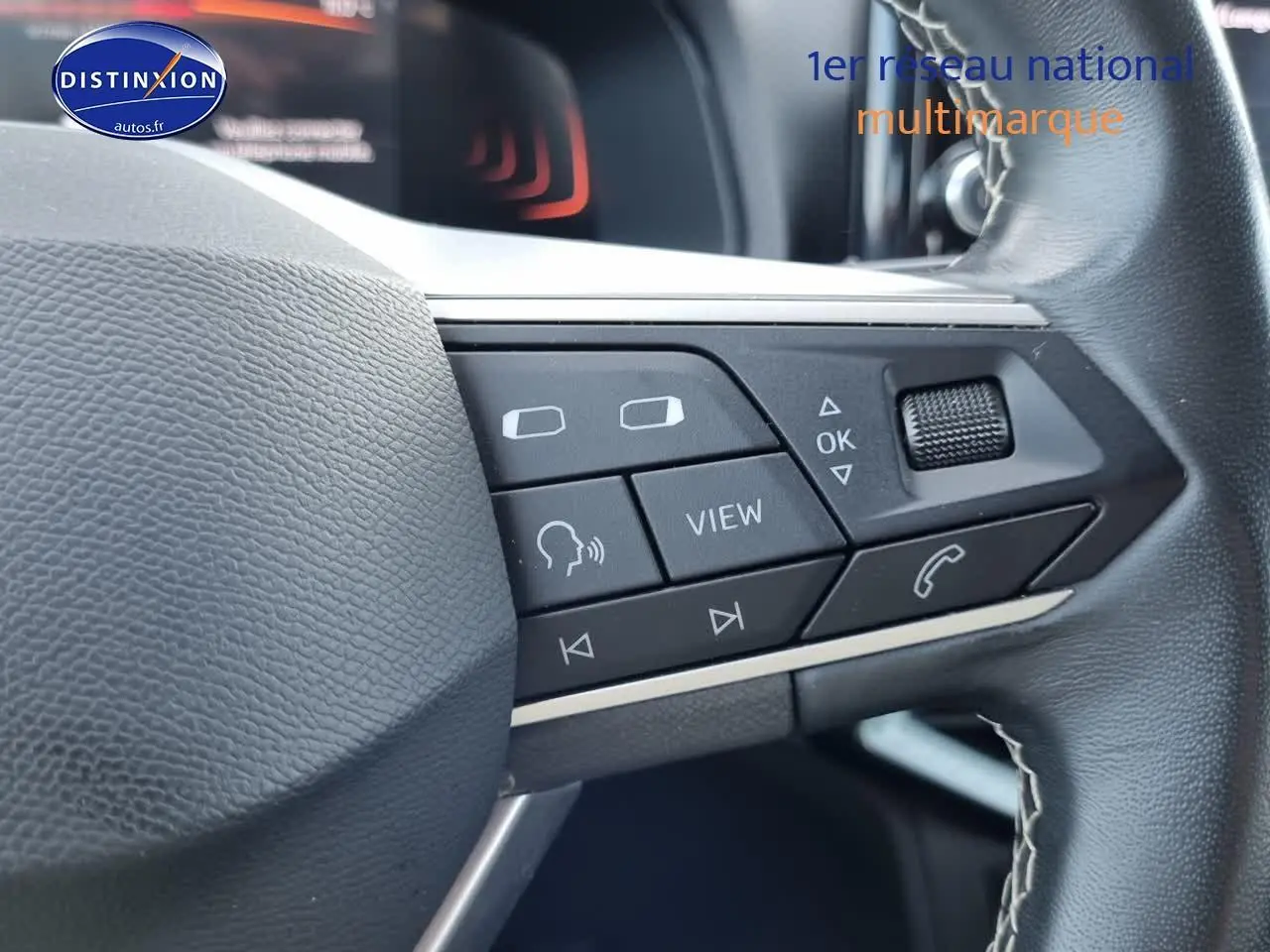 Gros plan sur les commandes multifonctions noires du volant cuir du SEAT Arona blanc, version 2023.