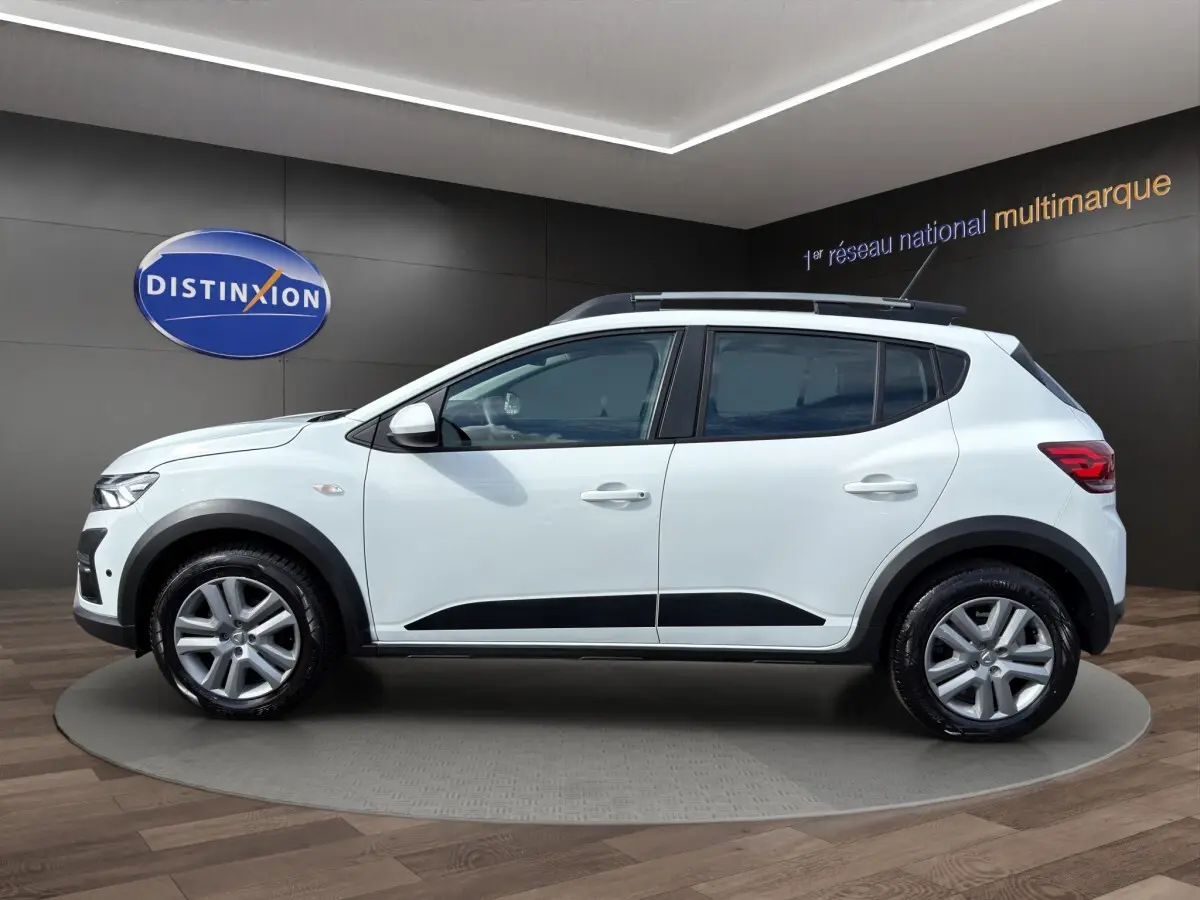Vue de profil côté gauche d'une Dacia Sandero Stepway blanche avec protections noires et jantes alliage.