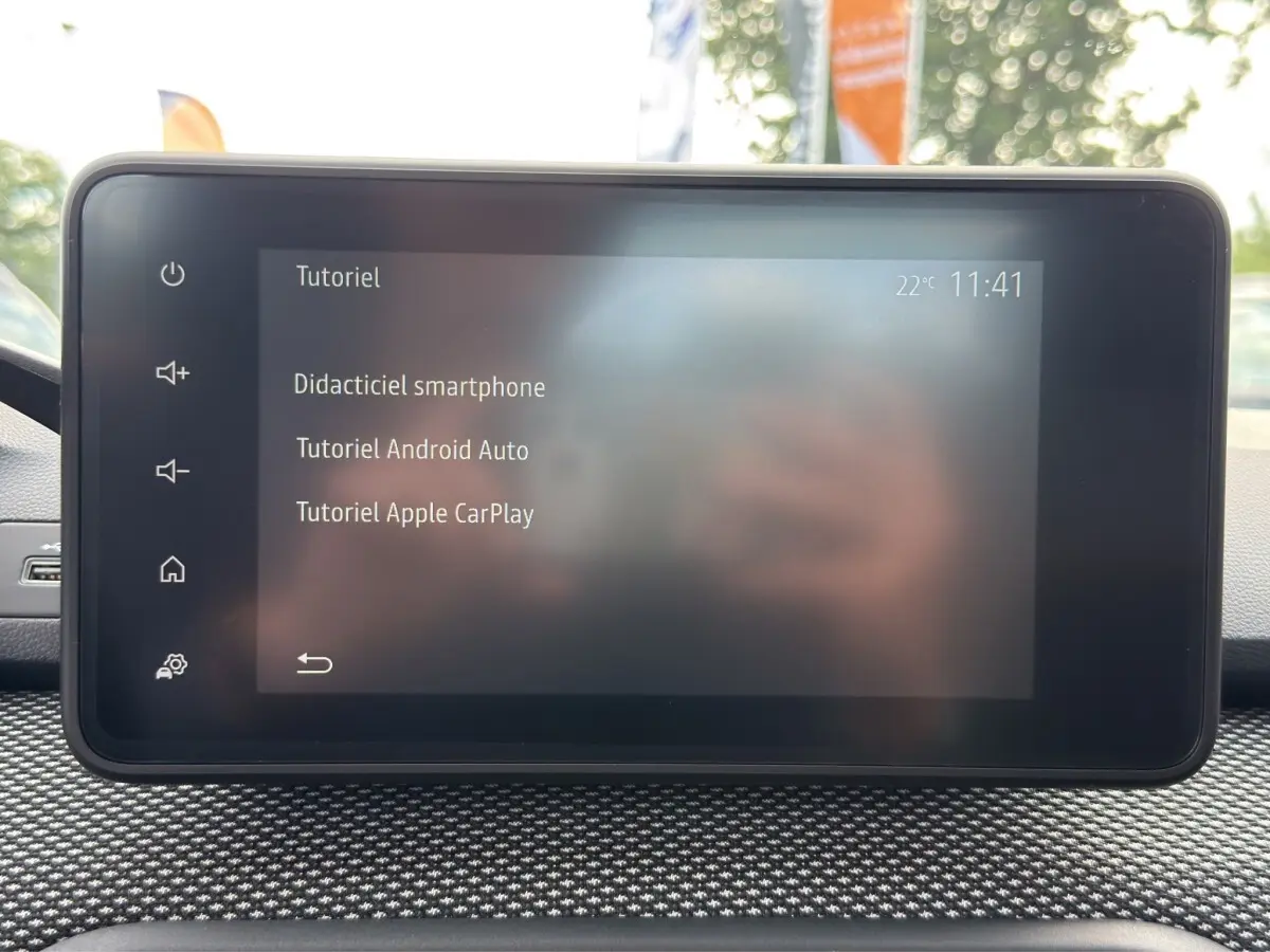Écran tactile central affichant un tutoriel smartphone dans l’habitacle d’une Dacia Sandero Stepway blanche.