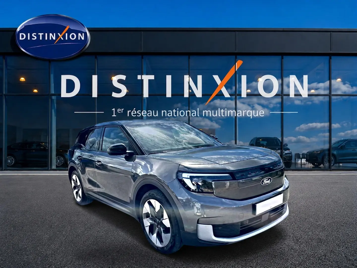 Ford Explorer électrique gris métallisé vu en 3/4 avant droit devant une vitrine avec logo Distinxion.