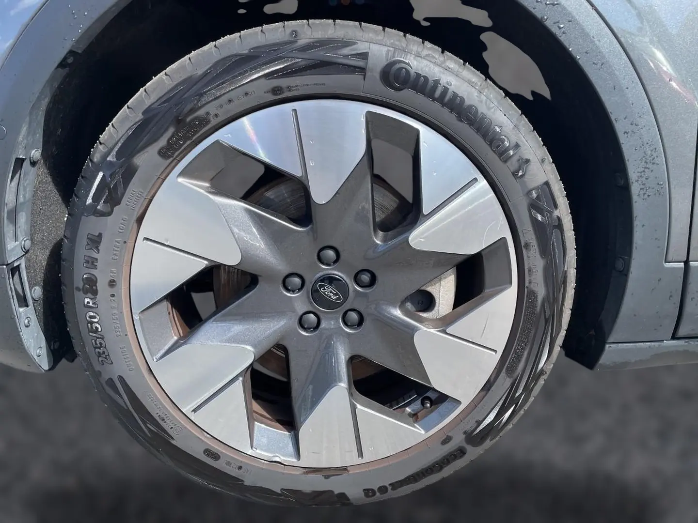 Gros plan sur la jante alu grise et noire du Ford Explorer électrique gris, avec pneu Continental visible.