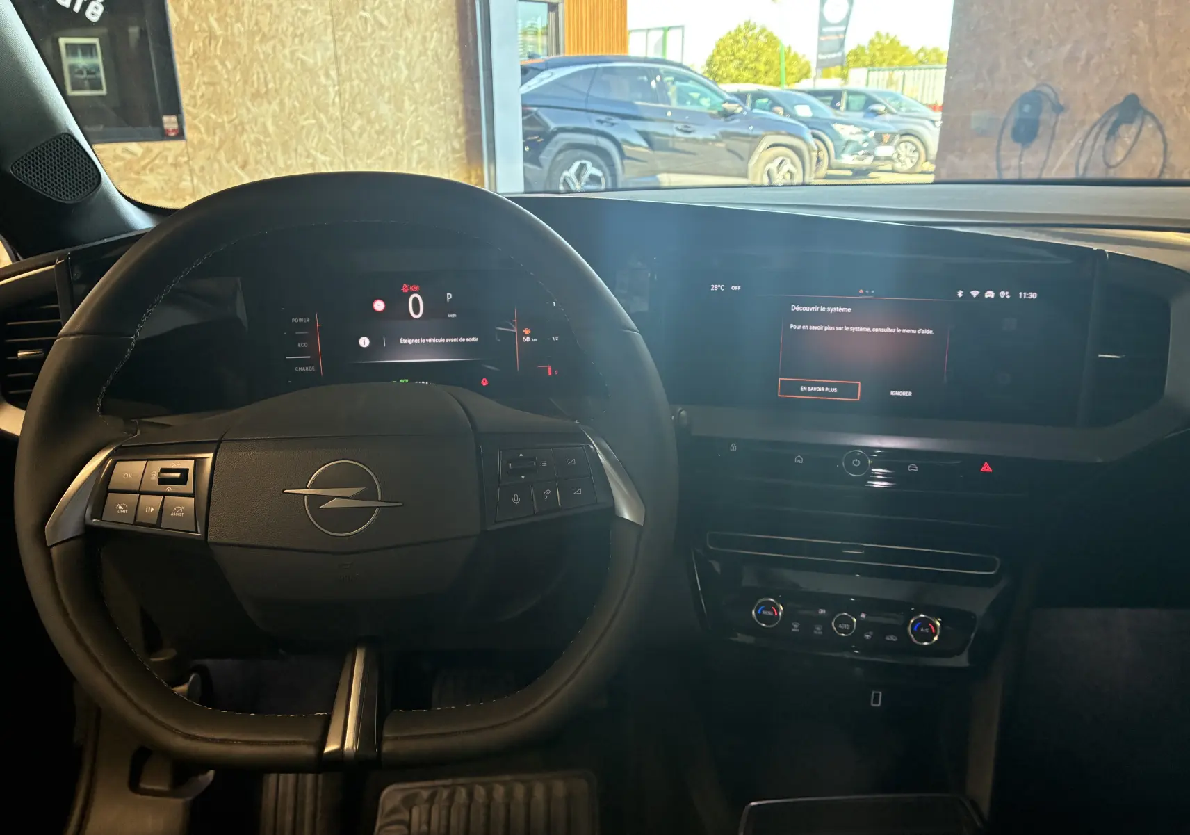 Vue intérieure du poste de conduite de l'Opel Mokka noir 2025, avec tableau de bord numérique et écran tactile central.