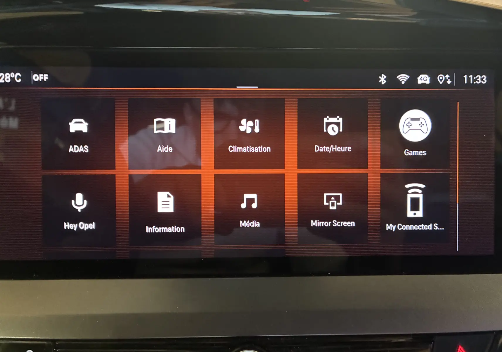 Écran tactile central de l'Opel Mokka 2025 noir, affichant le menu principal avec options connectées et climatisation.