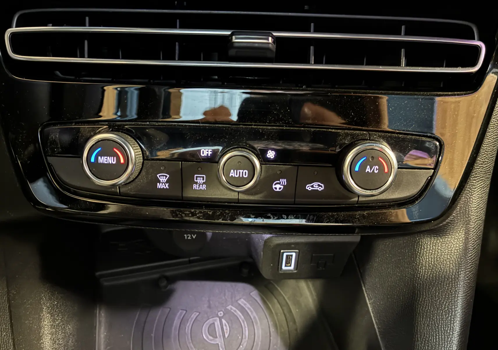 Vue rapprochée de la console centrale noire de l’Opel Mokka 2025, avec commandes de climatisation et port USB visibles.
