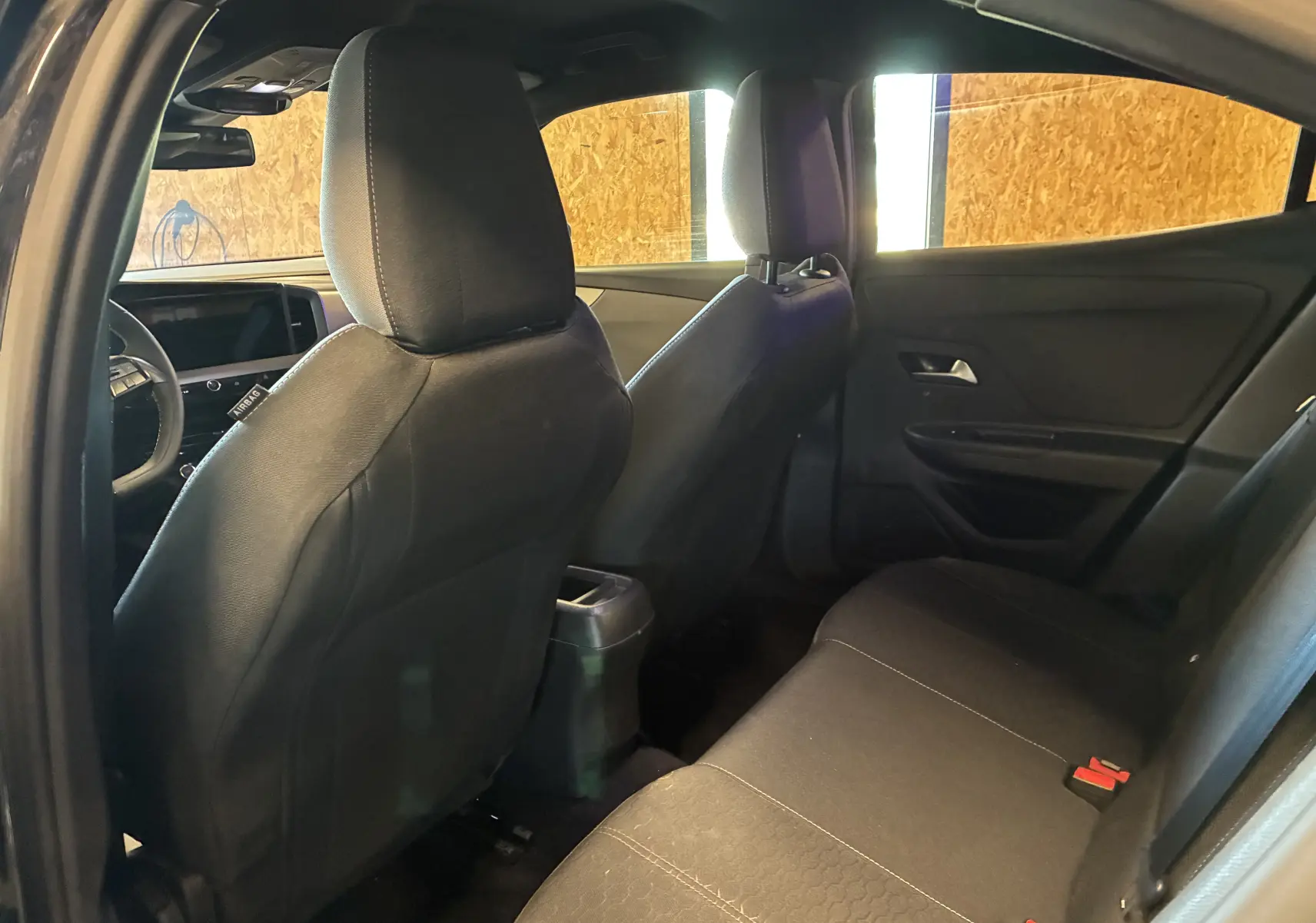Vue intérieure arrière côté gauche de l’Opel Mokka 2025 noire, montrant les sièges et la partie arrière du tableau de bord.