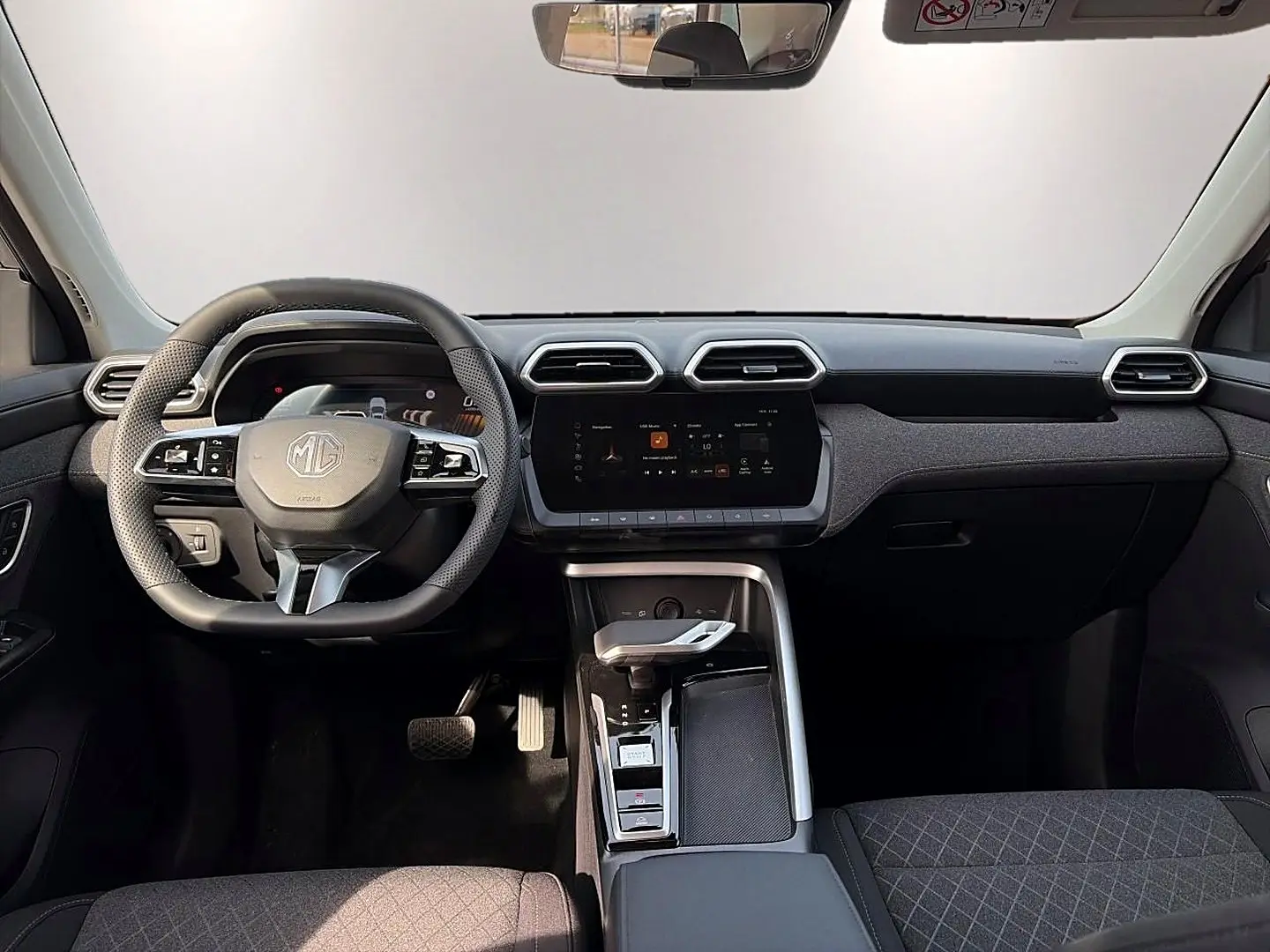 Vue intérieure avant du MG ZS Cosmic Silver 2026, avec tableau de bord moderne et volant multifonction noir.