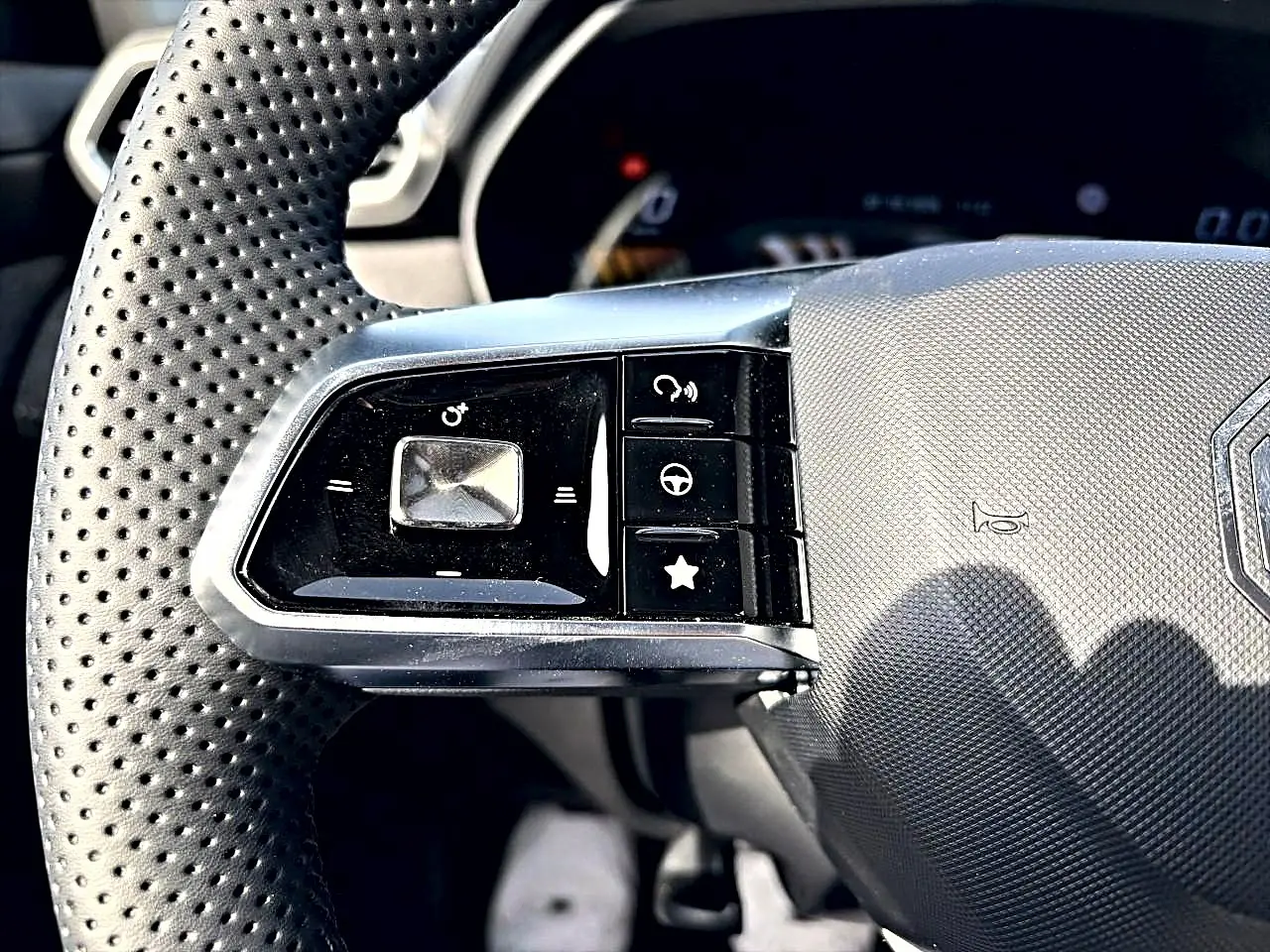 Gros plan sur les commandes gauche du volant perforé du MG MOTOR ZS 1.5 hybrid 197 Cosmic Silver 2026.