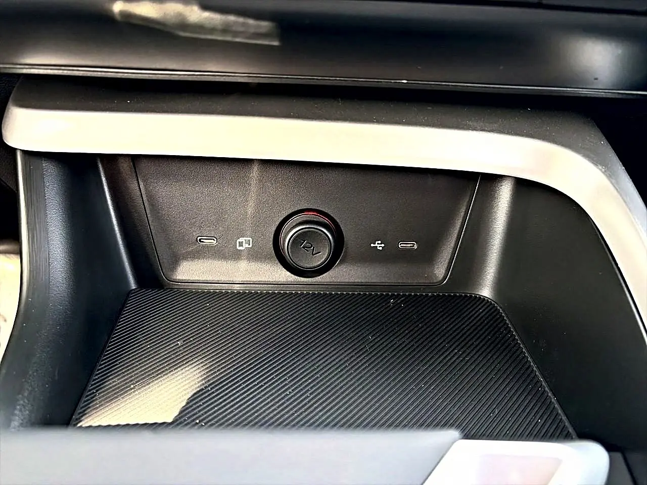 Gros plan sur la console centrale noire du MG Motor ZS 1.5 hybrid 197 avec prise 12V et ports USB visibles.