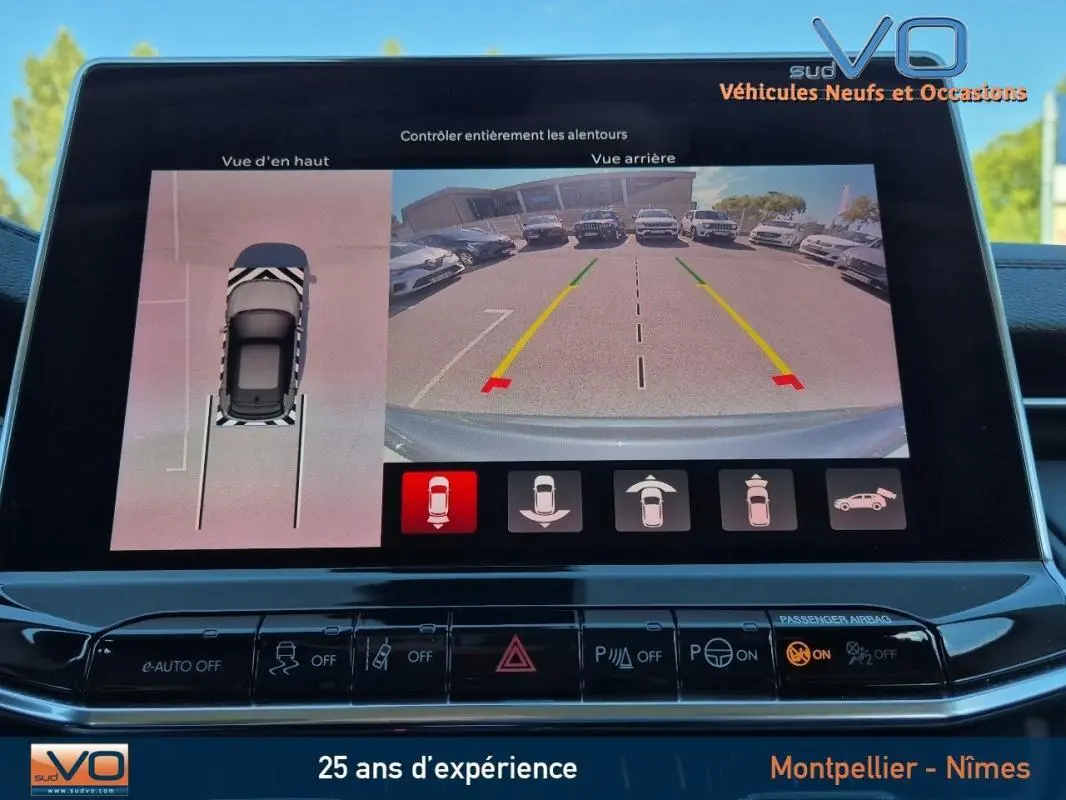 Écran tactile du Jeep Compass gris 2024 montrant la caméra de recul et la vue en 3D de stationnement assisté.