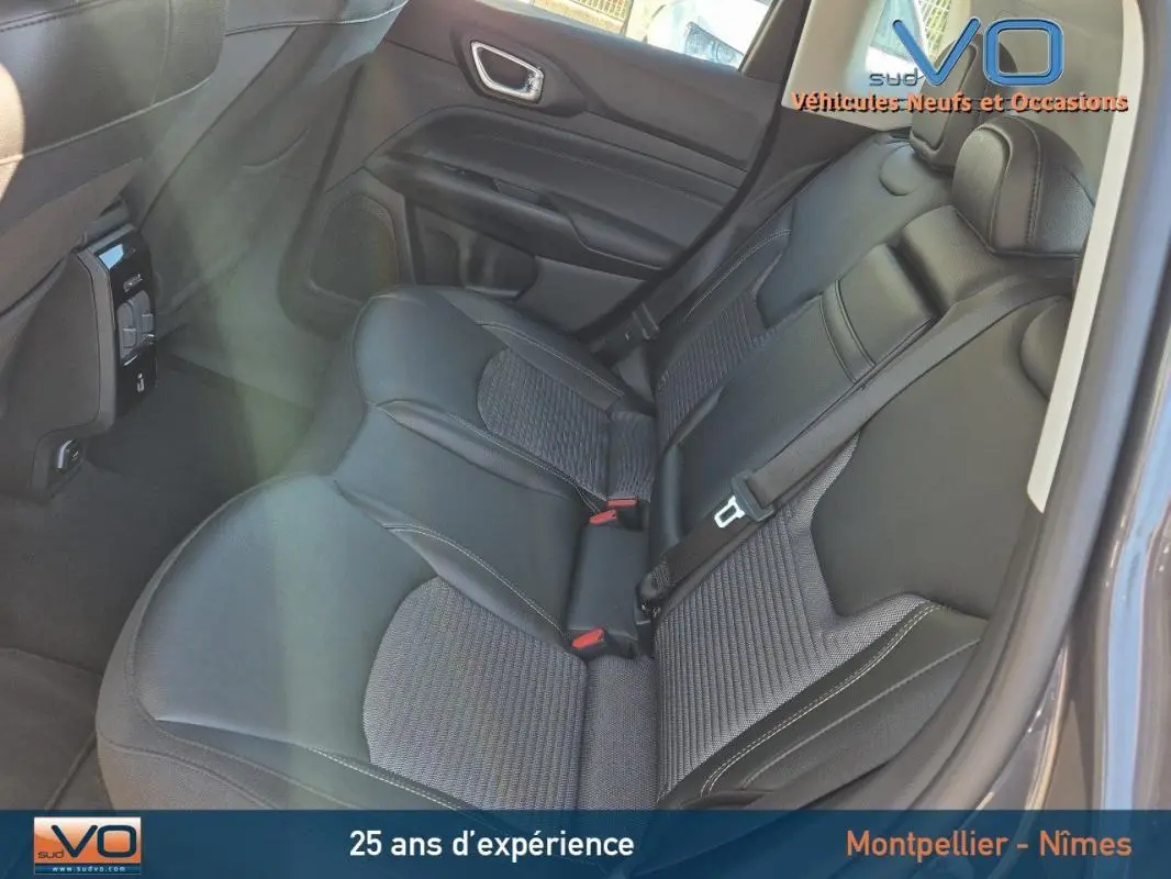 Vue intérieure côté droit des sièges arrière en cuir noir du Jeep Compass gris 2024 avec ceinture de sécurité visible.