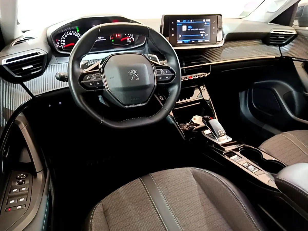Intérieur Peugeot 2008 gris foncé, vue du poste de conduite avec volant compact et écran tactile central.