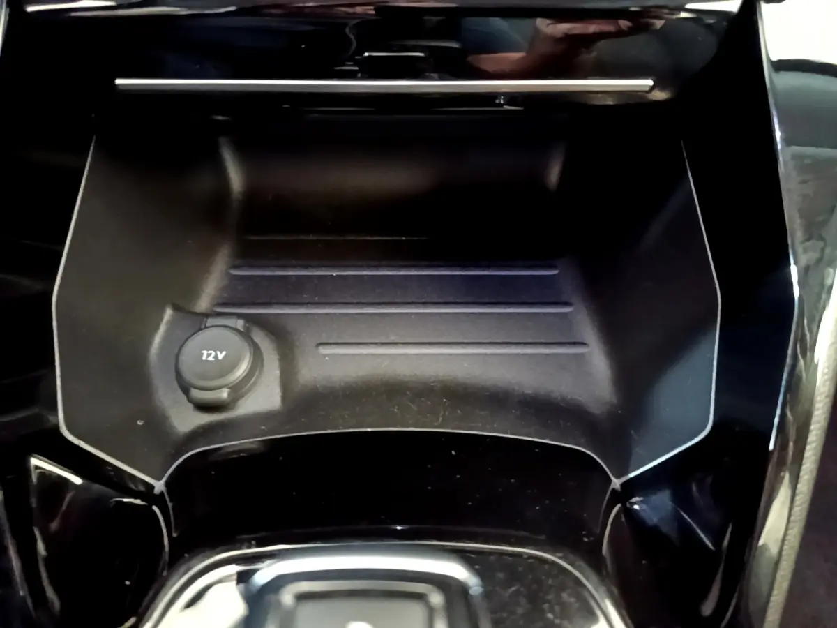 Prise 12V dans le rangement central avant noir brillant d'un Peugeot 2008 gris foncé, version 2022.