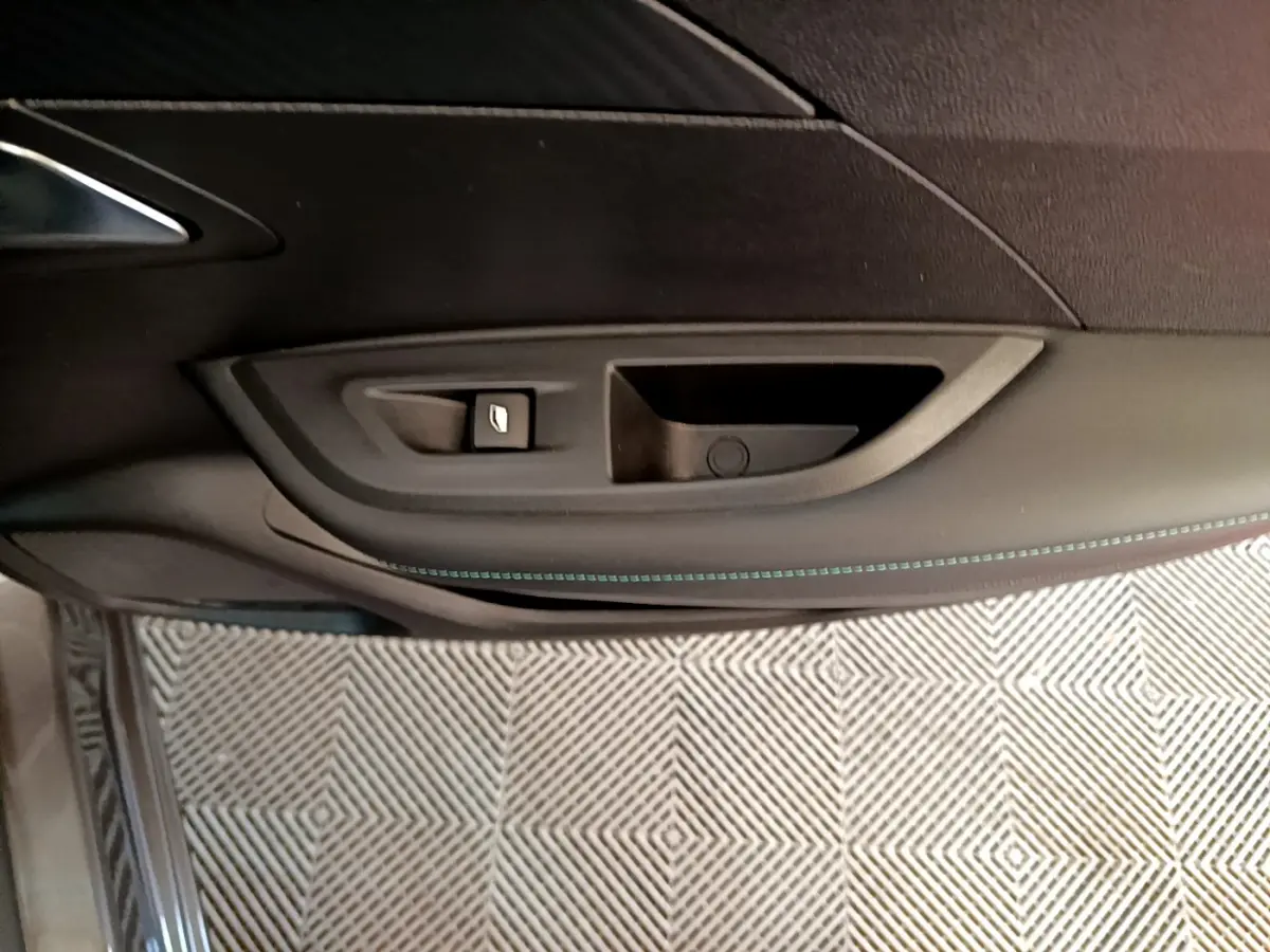 Poignée intérieure côté gauche de porte noire avec bouton de verrouillage sur Peugeot 2008 gris foncé 2022.