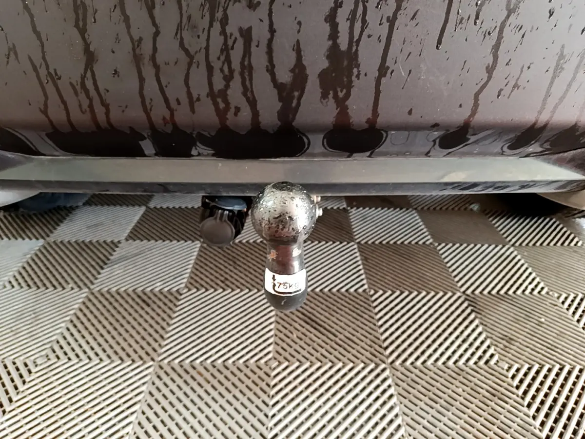 Gros plan sur l'attelage arrière d'une Peugeot 2008 gris foncé, montrant la boule de remorquage avec étiquette 75 kg.