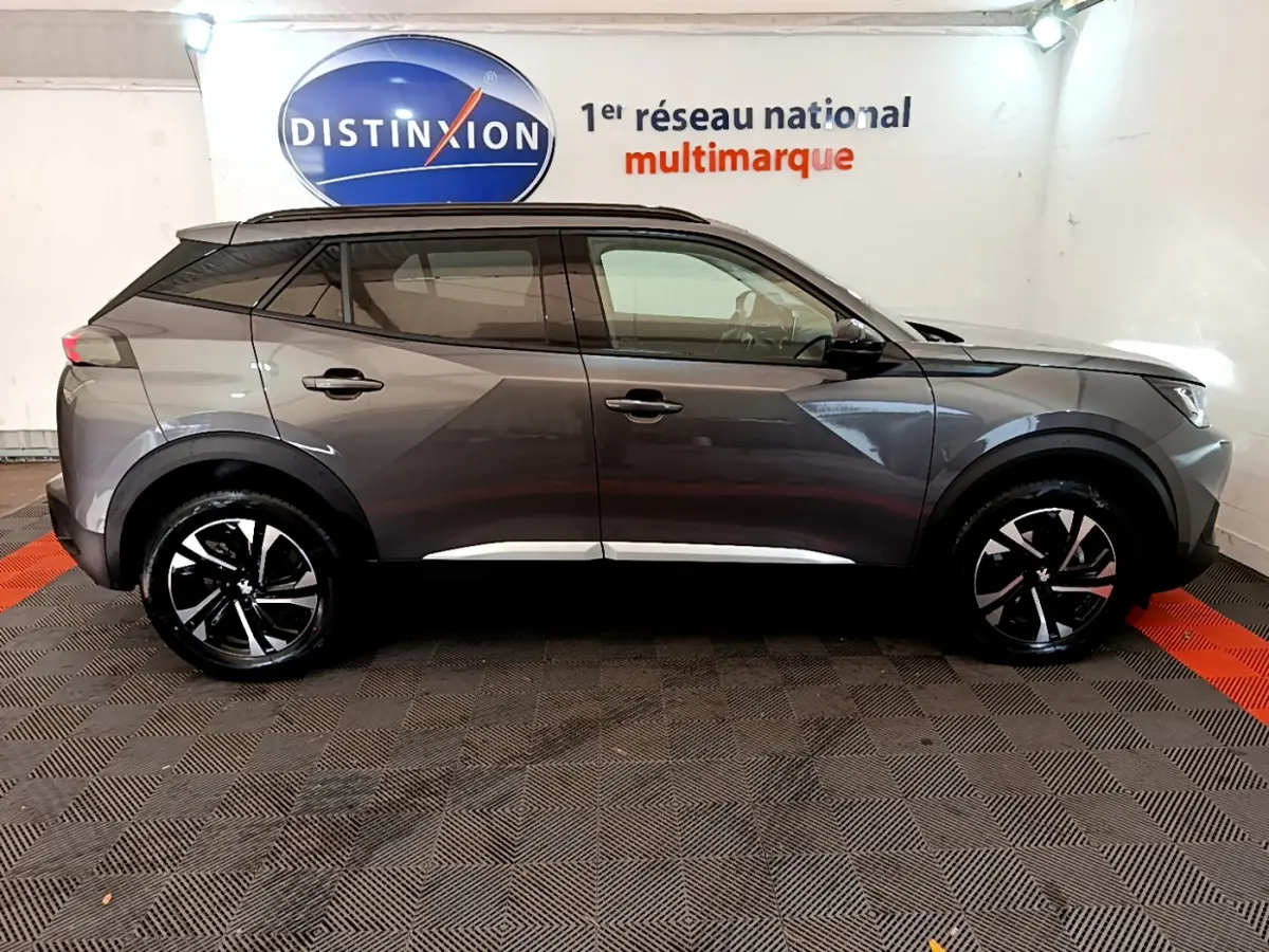 Peugeot 2008 gris foncé vue de profil côté gauche, avec jantes noires et toit noir contrastant.