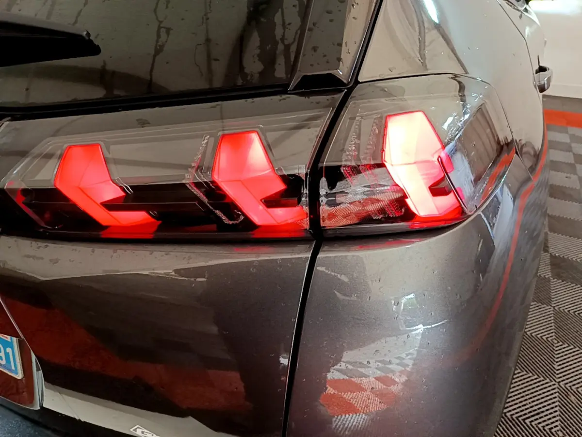 Gros plan sur le feu arrière droit rouge du Peugeot 2008 gris foncé, mettant en valeur son design LED distinctif.