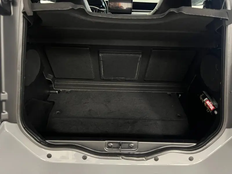 Coffre ouvert vu de dessus sur la LIGIER JS50 SPORT ULTIMATE E5+ gris 2025, avec intérieur noir et bouteille Motul visible à droite.