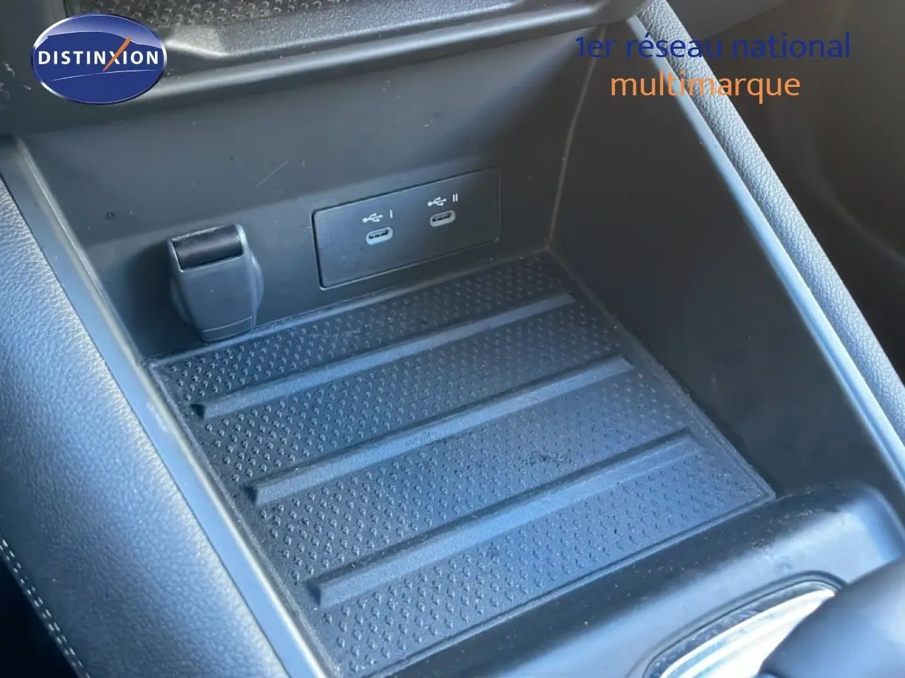 Gros plan sur la console centrale de la Renault Symbioz 2025, montrant deux ports USB-C et un espace de rangement noir texturé.