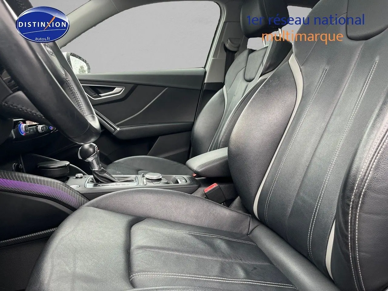 Vue intérieure côté conducteur de l'Audi Q2 2018 avec sièges cuir noir et console centrale visible.