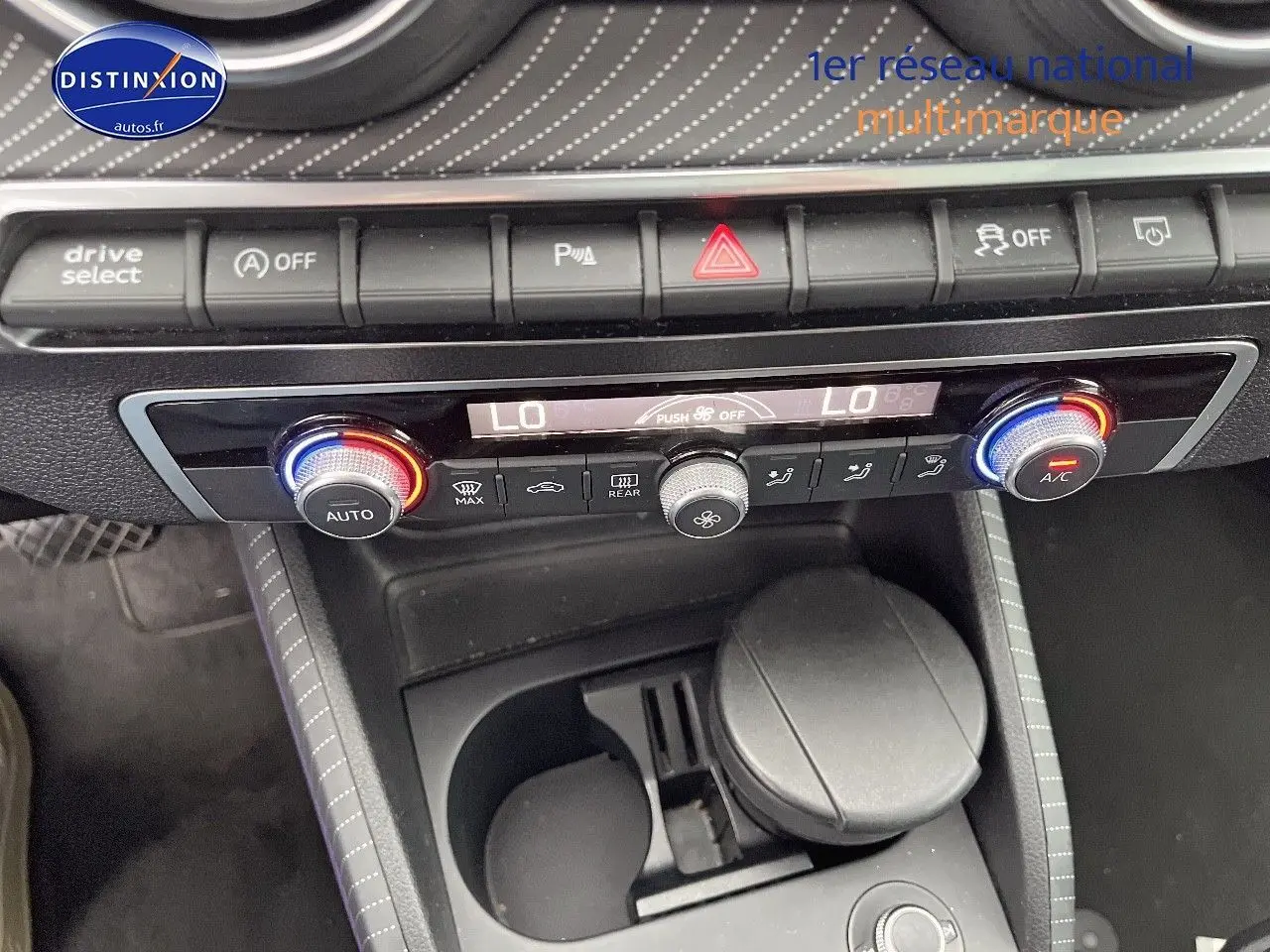 Vue rapprochée de la console centrale de l'Audi Q2, avec commandes climatisation et boutons multifonctions.