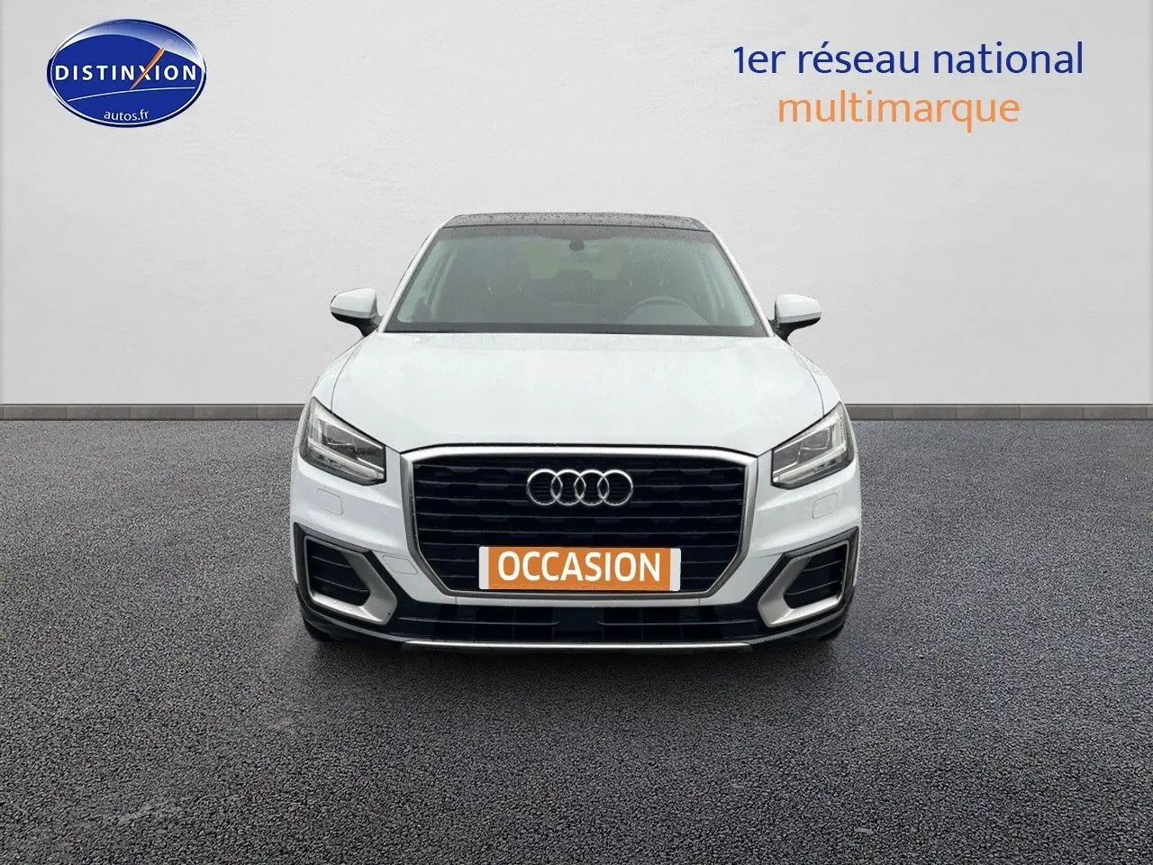 Audi Q2 blanc Ibis vue de face avec calandre noire et plaque "OCCASION" orange visible.