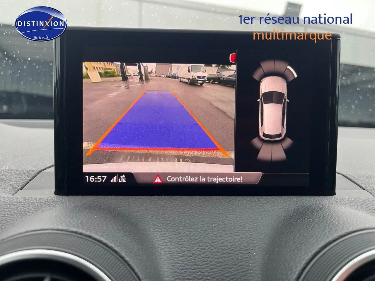 Écran central montrant la caméra de recul et l'Audi Parking System Plus d'un Audi Q2 blanc Ibis, vue intérieure.