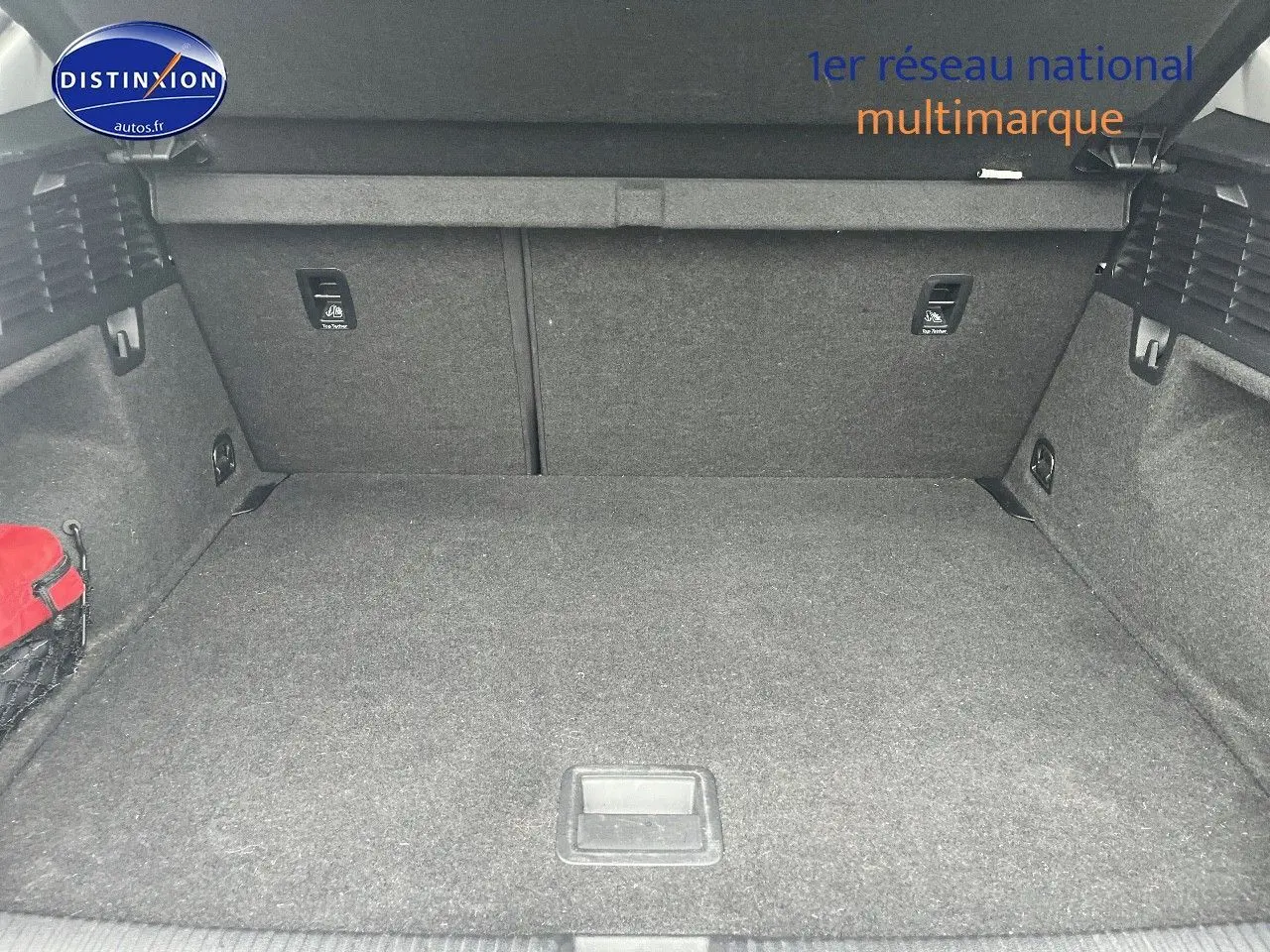 Coffre ouvert vu de face de l'Audi Q2 blanc Ibis, montrant un espace de chargement propre et spacieux.