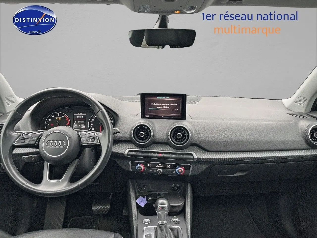 Vue intérieure du tableau de bord et volant cuir noir de l'Audi Q2 2018 avec écran central et commandes climatisation.