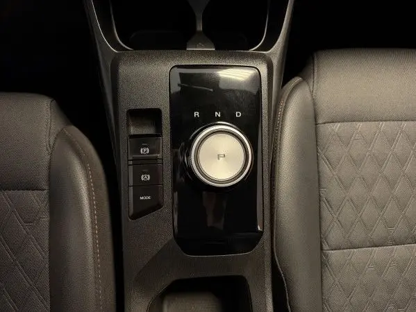 Vue plongeante sur la console centrale noire du MG3 Cosmic Silver, avec molette de boîte auto et sièges en similicuir noir.