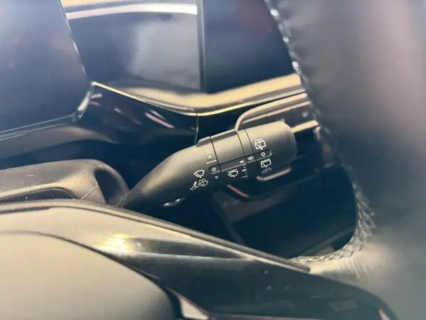 Gros plan sur la commande des essuie-glaces côté droit du volant dans l’habitacle noir du MG3 Cosmic Silver.