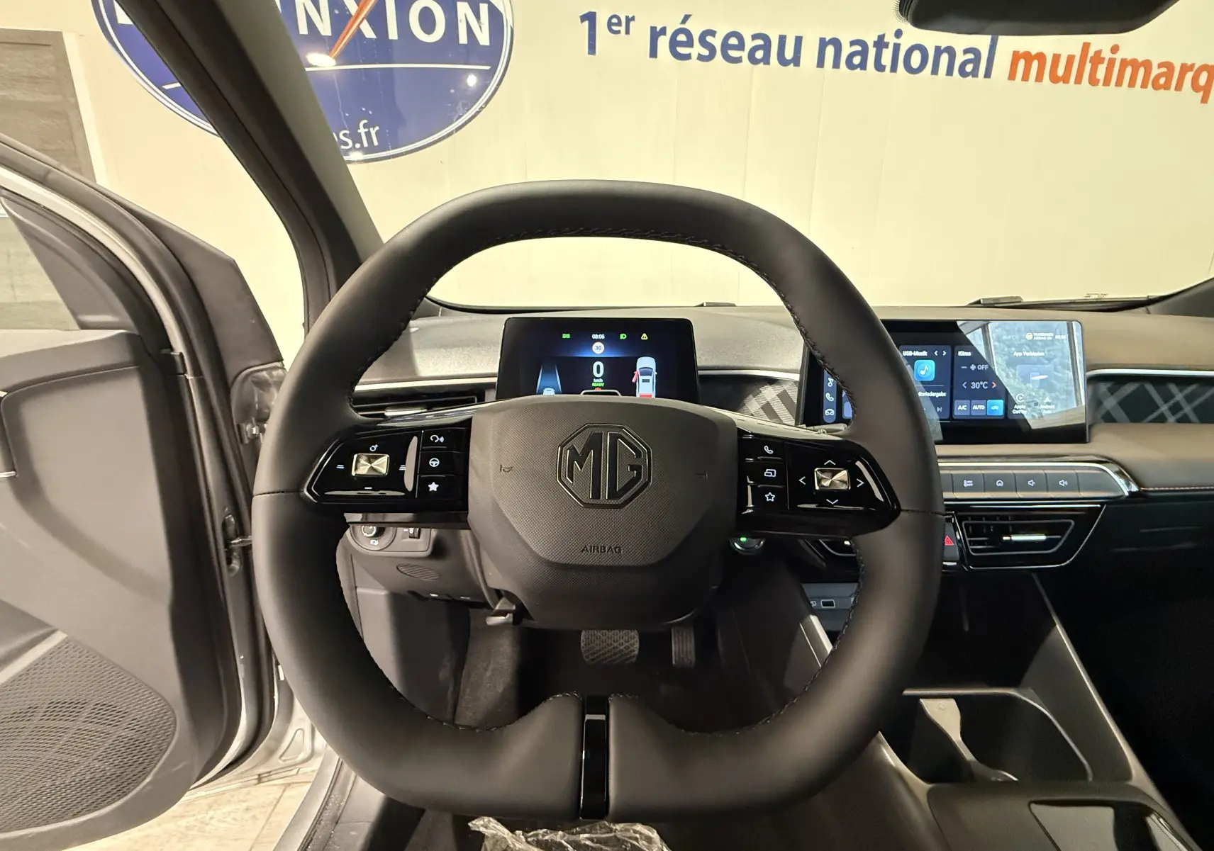 Vue centrée sur le volant noir du MG3 1.5 L Hybrid+ 2026 avec tableau de bord digital et écran tactile en arrière-plan.