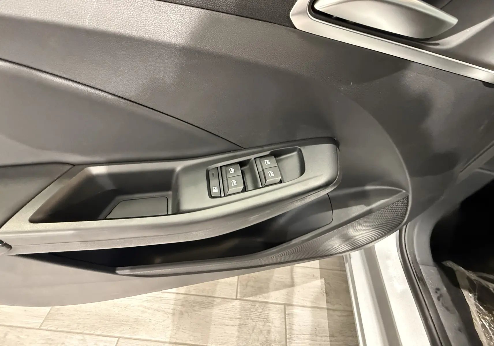 Détail de la porte côté conducteur du MG3 Cosmic Silver 2026, montrant les commandes des vitres électriques et la poignée intérieure.