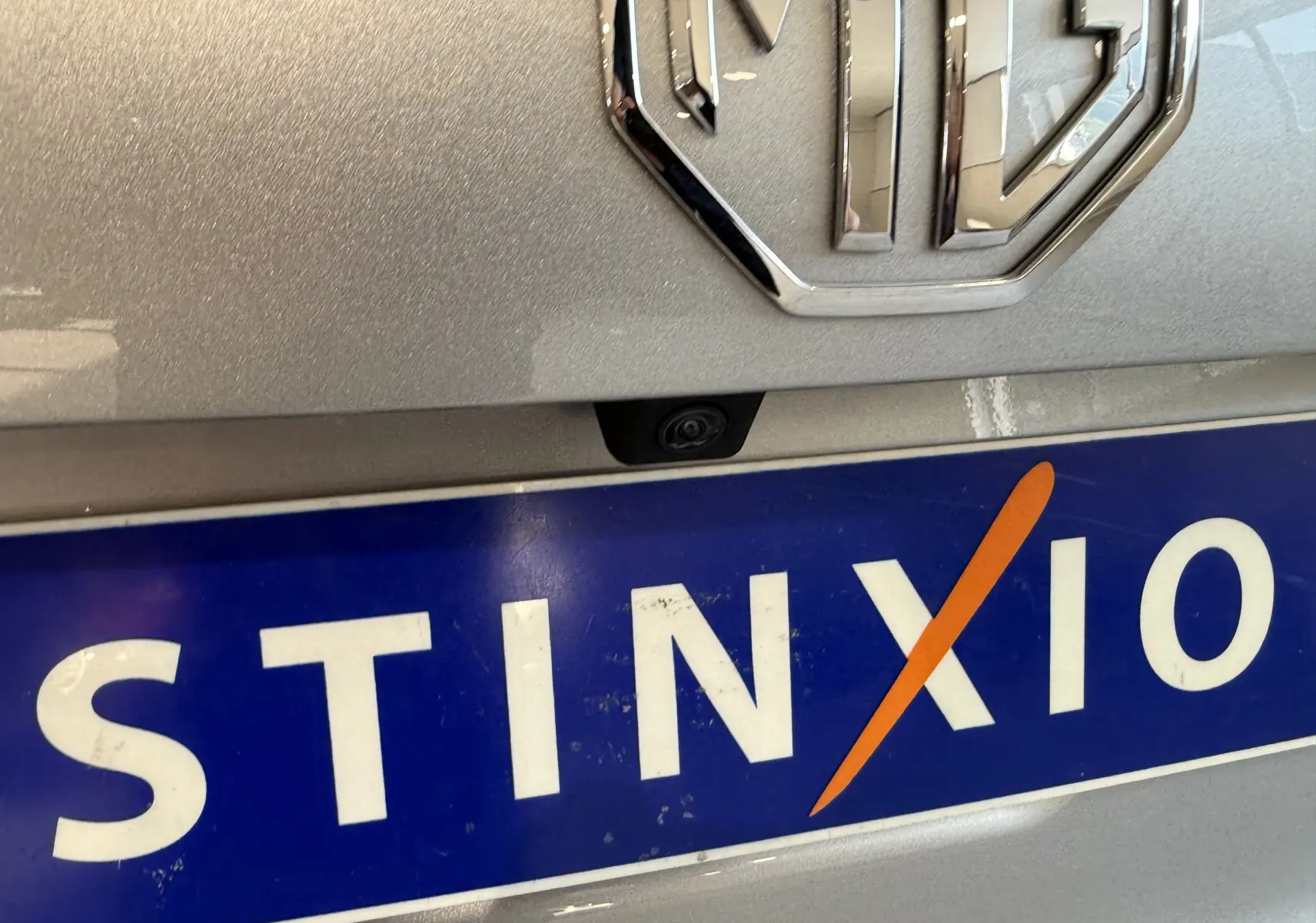 Gros plan sur l'arrière d'une MG3 Cosmic Silver, mettant en valeur le logo MG et la caméra de recul au-dessus de la plaque.