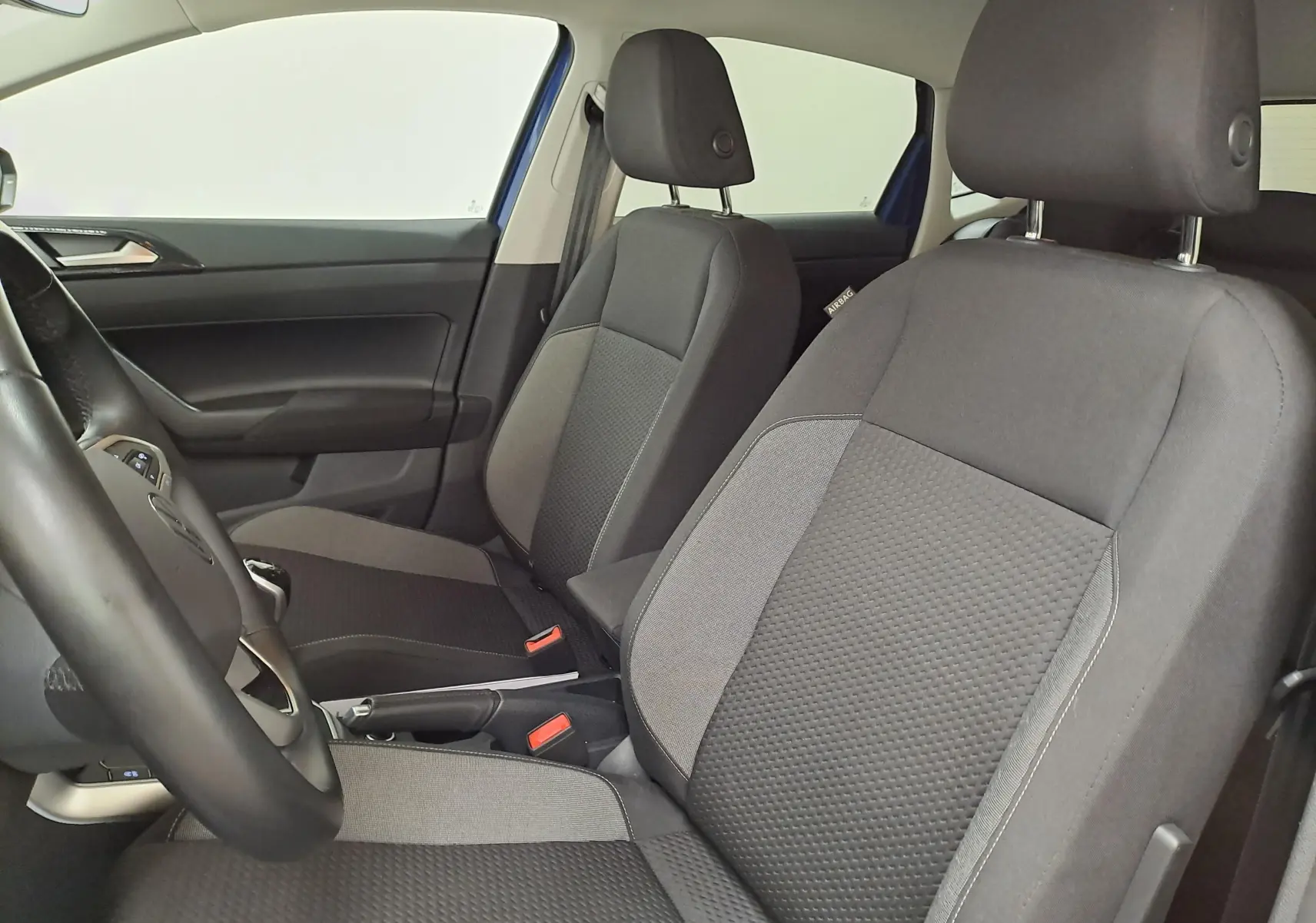 Vue intérieure côté gauche montrant les sièges avant en tissu noir et gris d'une Volkswagen Polo 2025.