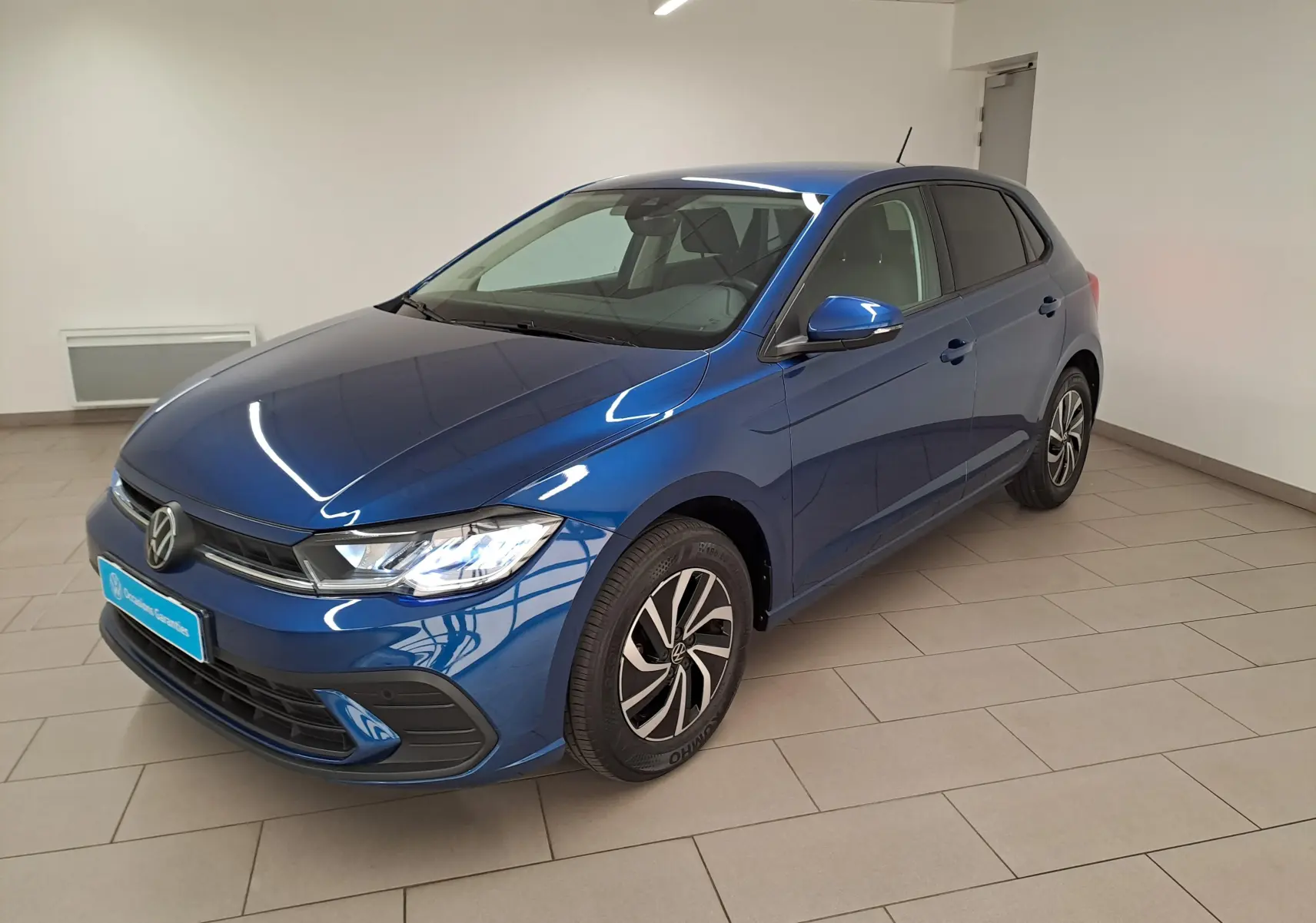 Volkswagen Polo 1.0 TSI 95 VW Edition bleu récif vue 3/4 avant droit en intérieur avec jantes alliage 15 pouces.