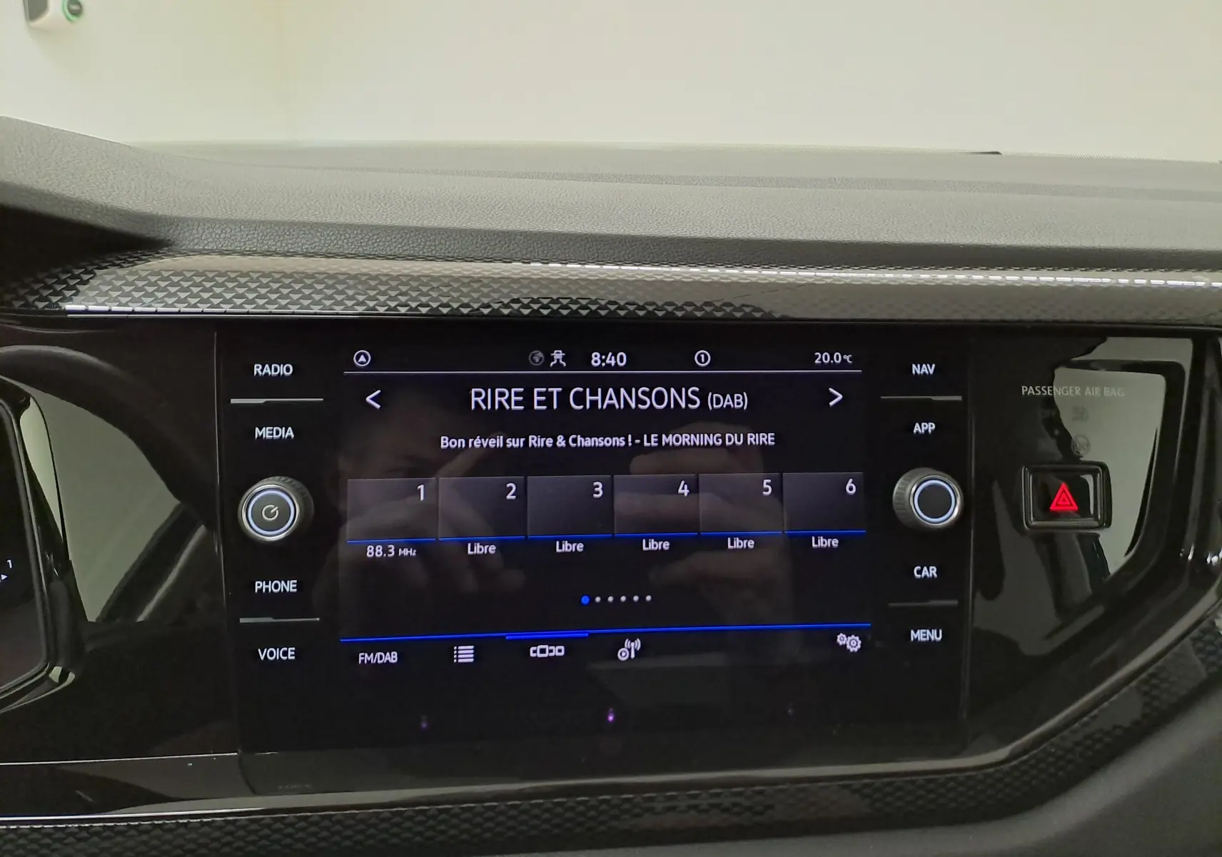 Vue rapprochée de l'écran tactile central noir du tableau de bord d'une Volkswagen Polo 2025, affichant une radio DAB.