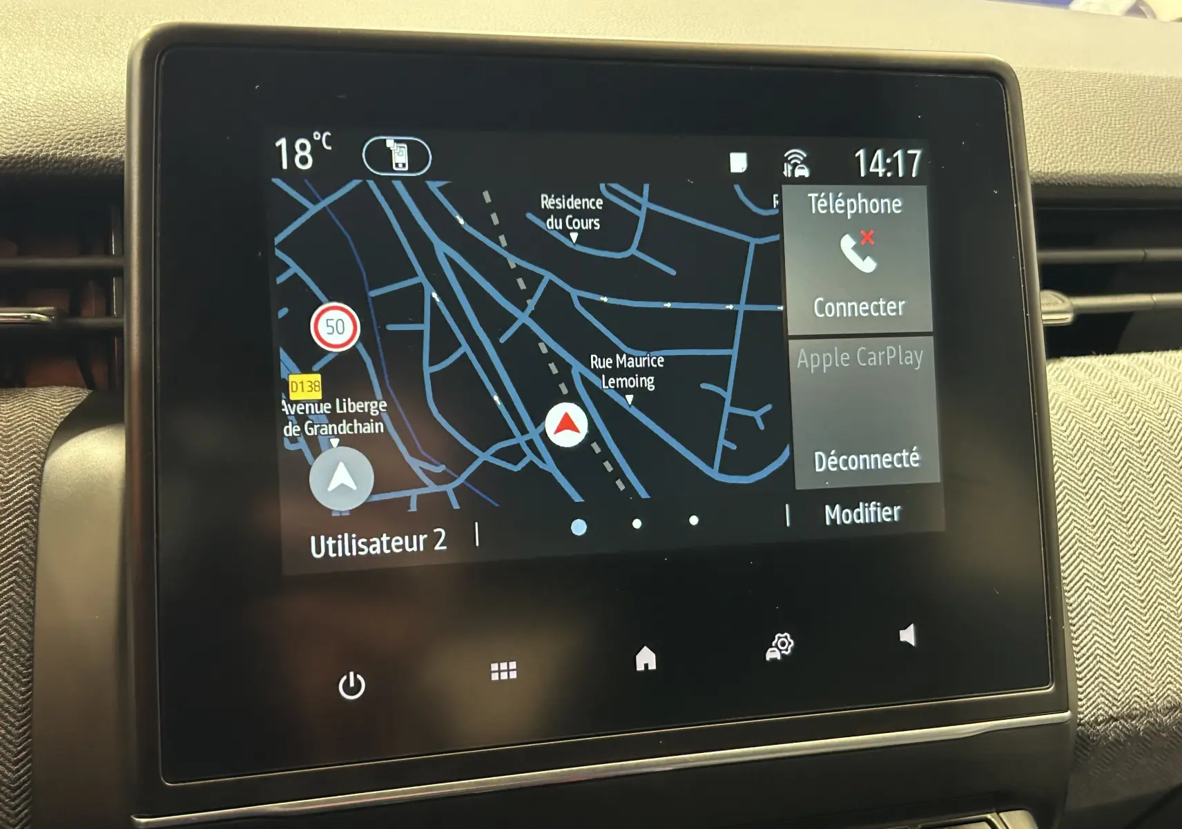 Écran tactile central du tableau de bord de la Renault Clio V gris Rafale, affichant la navigation GPS et options téléphone.