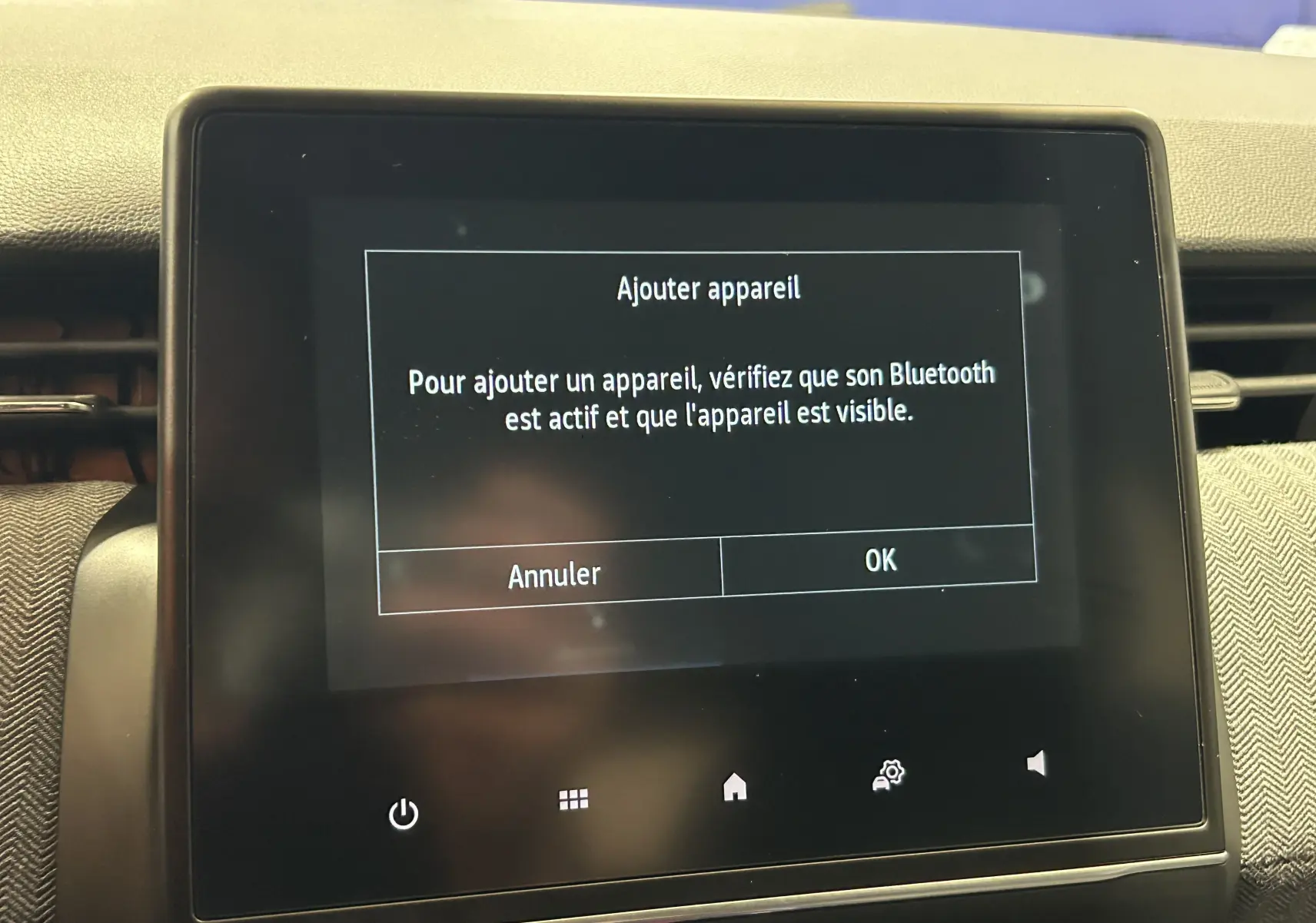 Écran tactile central de la Renault Clio V gris Rafale, affichant un message d'ajout d'appareil Bluetooth.