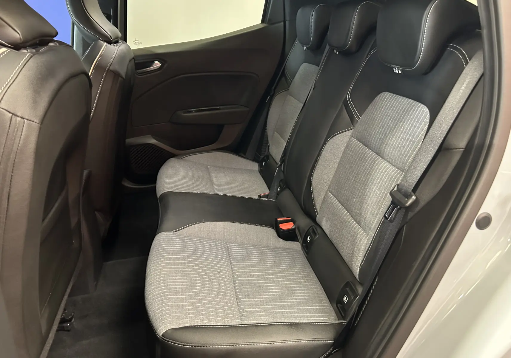 Vue latérale droite de la banquette arrière bicolore gris clair et noir de la Renault Clio V E-Tech Hybrid 2025.