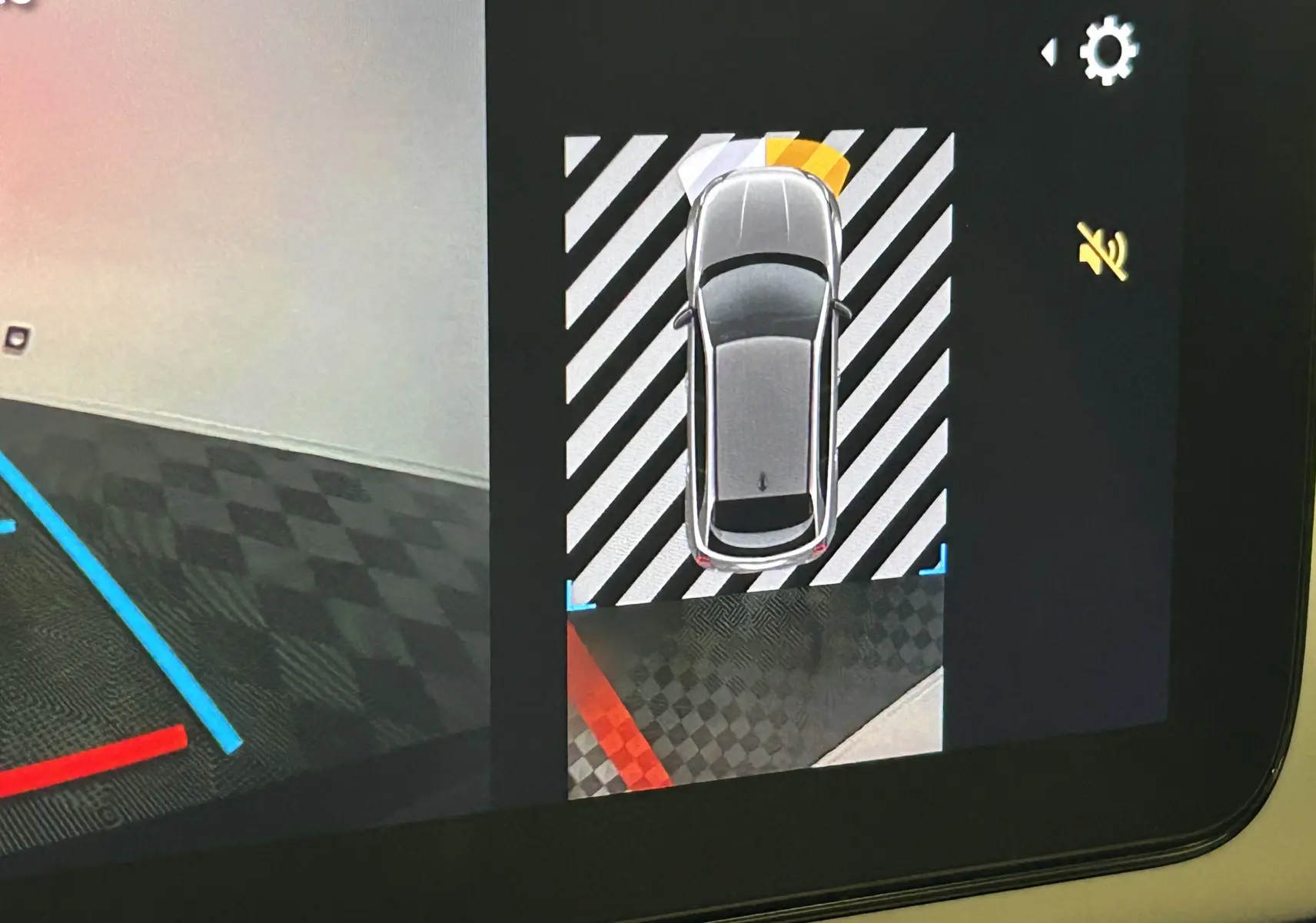 Vue écran de la caméra de recul montrant une Fiat 600 hybride 2024 en gris, avec alertes de proximité activées.