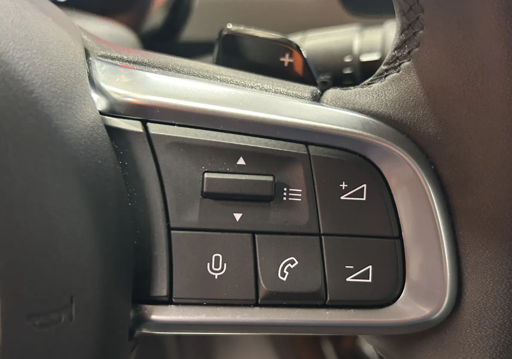 Gros plan sur les commandes au volant du FIAT 600 Hybrid 2024, boutons de volume et appels téléphoniques visibles.